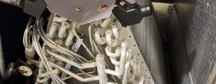 Dust and debris inside the lower section of a residential HVAC air handler during professional cleaning in Bradenton, Florida.
