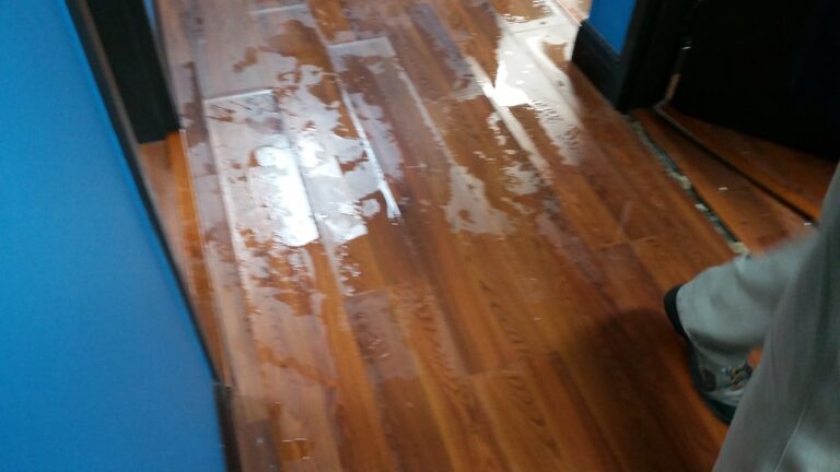 Hurricane Ian floodwater affecting glue-down hardwood flooring during water mitigation in Venice Florida 34293
